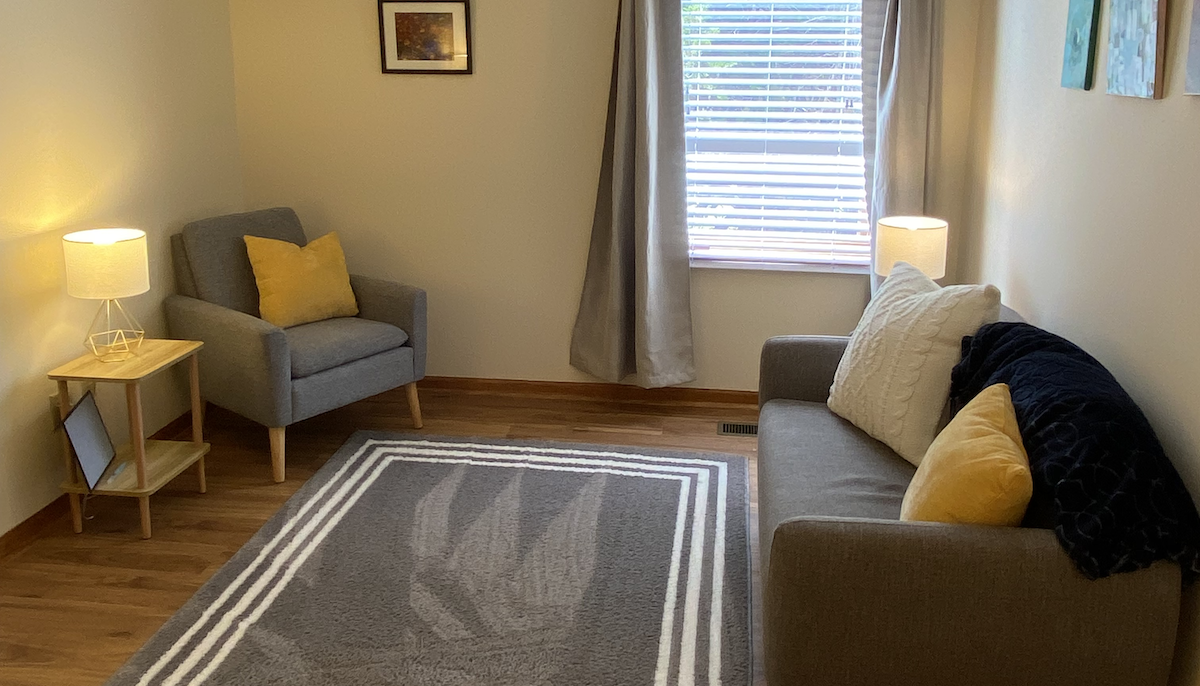 A photograph of the waiting area in Anne's space, showing a sofa and a chair