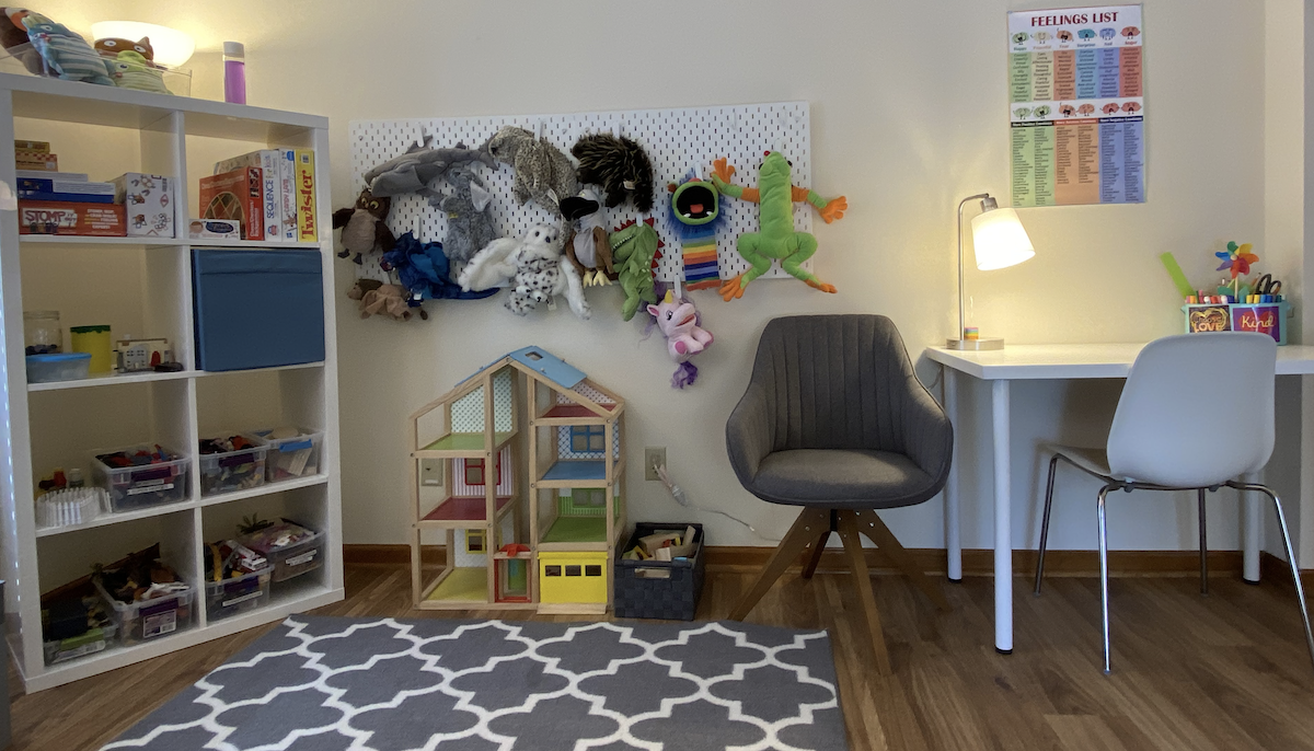 Why play therapy? A photograph of Anne's space in Lawrence, including play therapy resources such as toys and a wall of puppets