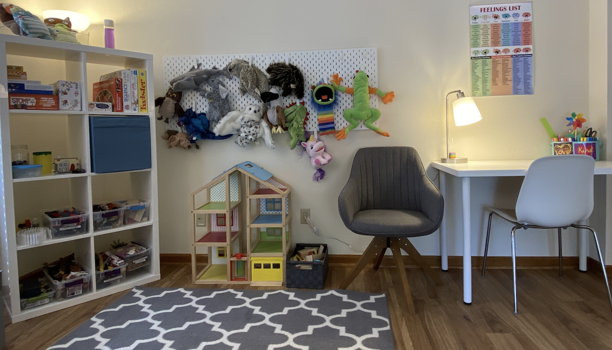 A photograph of Anne's space in Lawrence, including play therapy resources such as toys and a wall of puppets